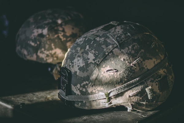 Military helmets and camouflage representing service members and veteran support.