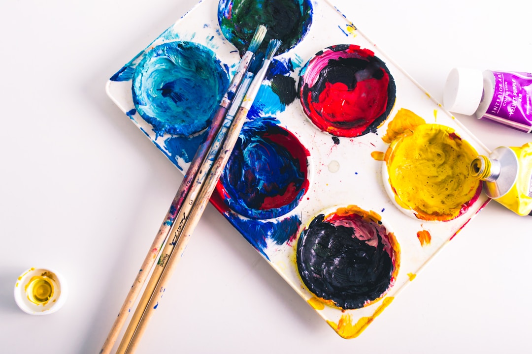 Colorful paints and brushes on a palette, illustrating a new hobby for fulfillment.