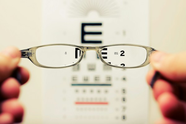 Eyeglasses over eye chart demonstrating vision correction for schoolwork.