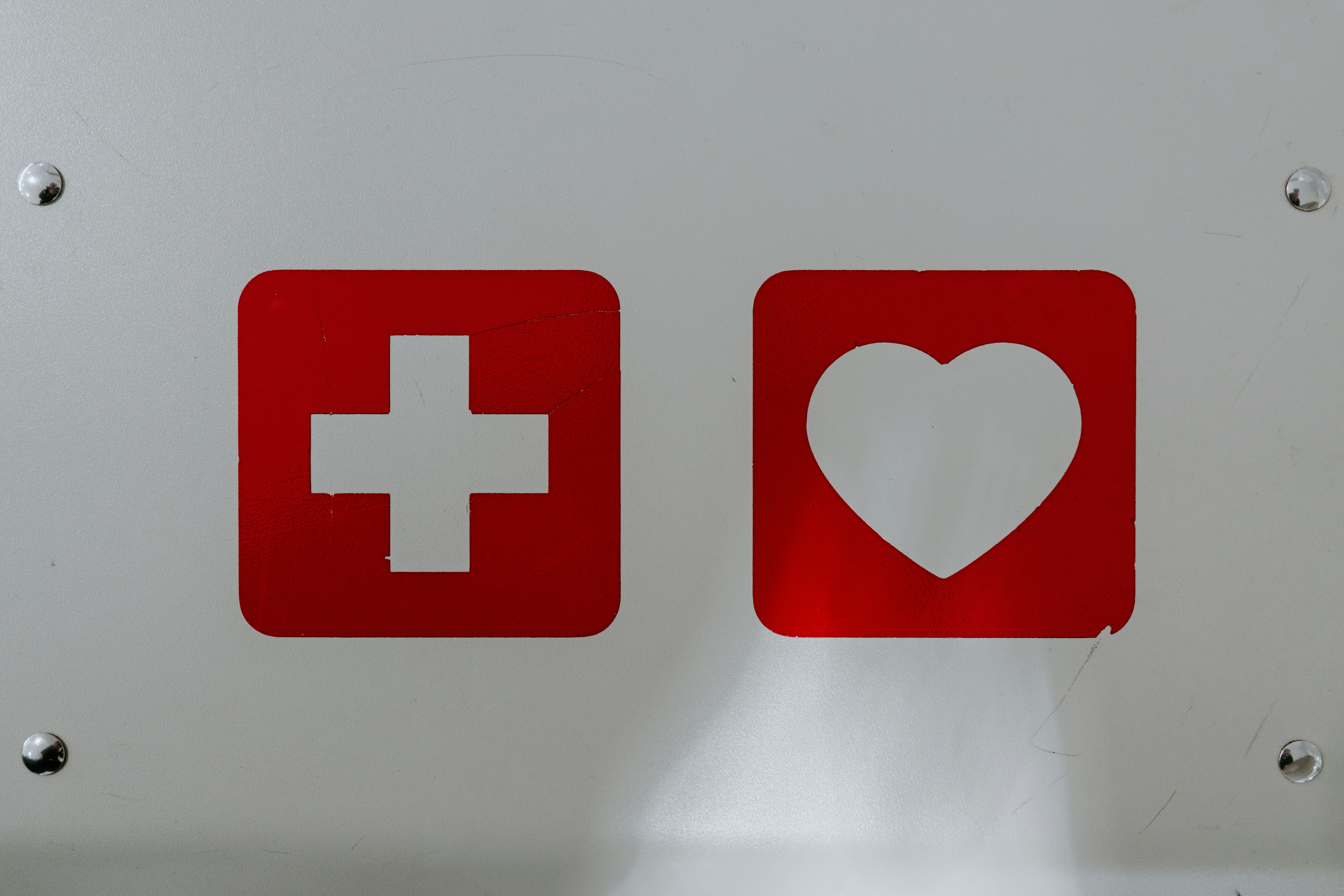Red cross symbol and heart, representing health and recovery after rehabilitation.