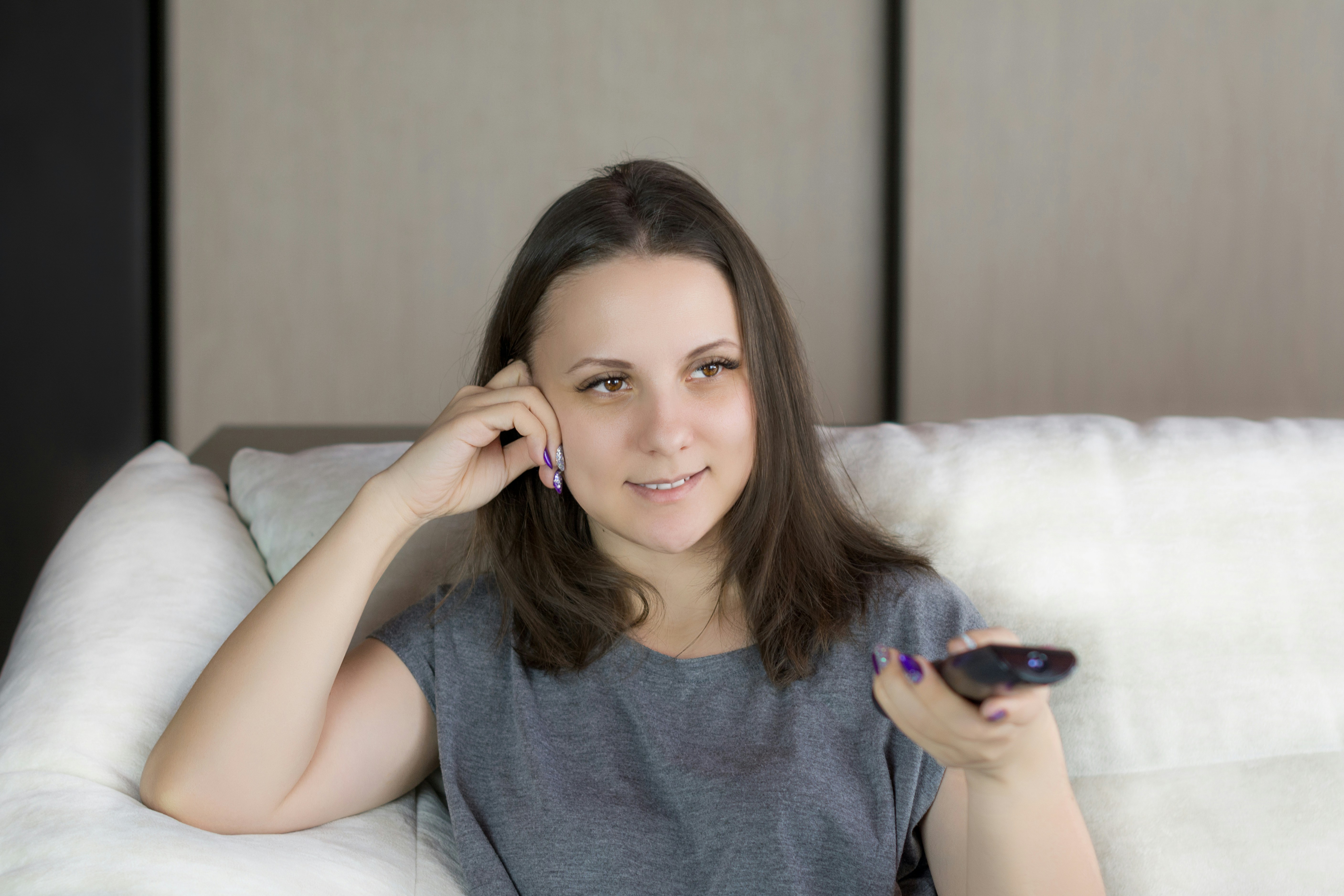Woman relaxing on couch watching movie during quarantine birthday.