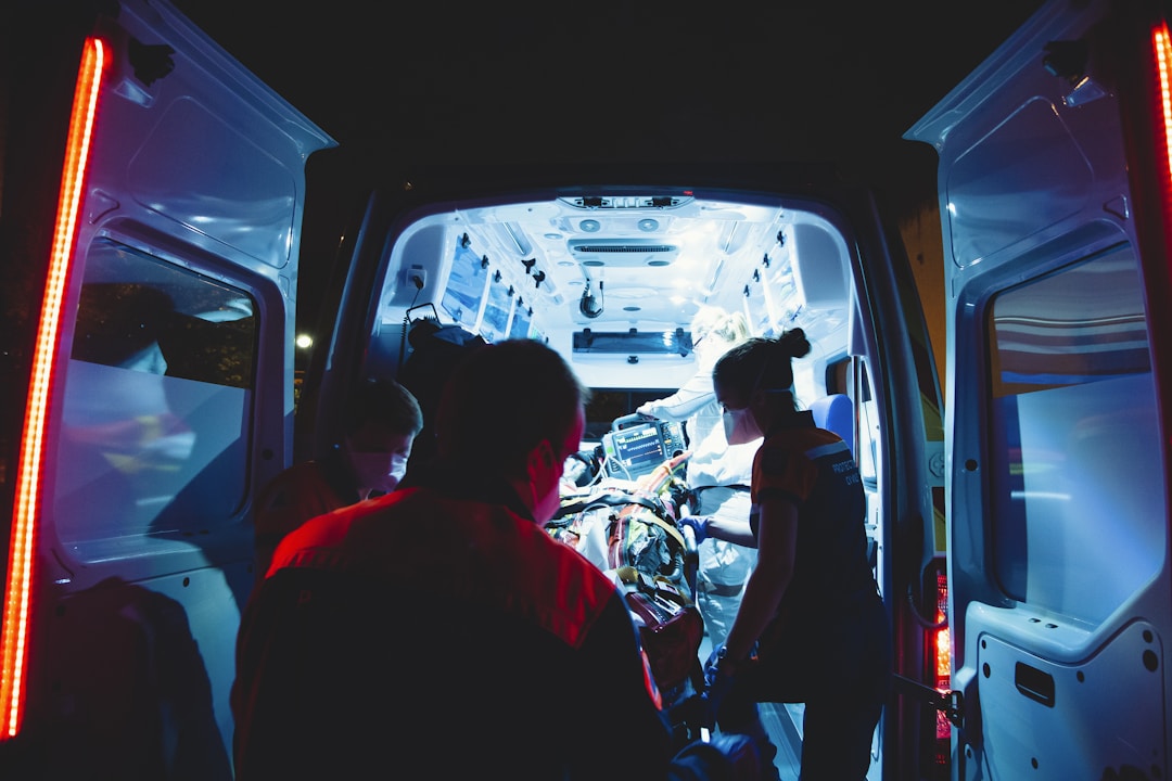 Emergency medical personnel attending to an injured person inside an ambulance after a rideshare accident.