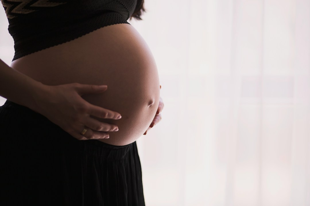 Expecting mother's pregnant belly and gentle touch, illustrating unique pregnancy experiences.