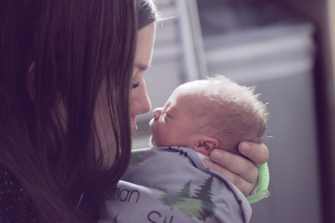 Mother gently embracing newborn baby, representing positive childbirth experience and maternal rights.