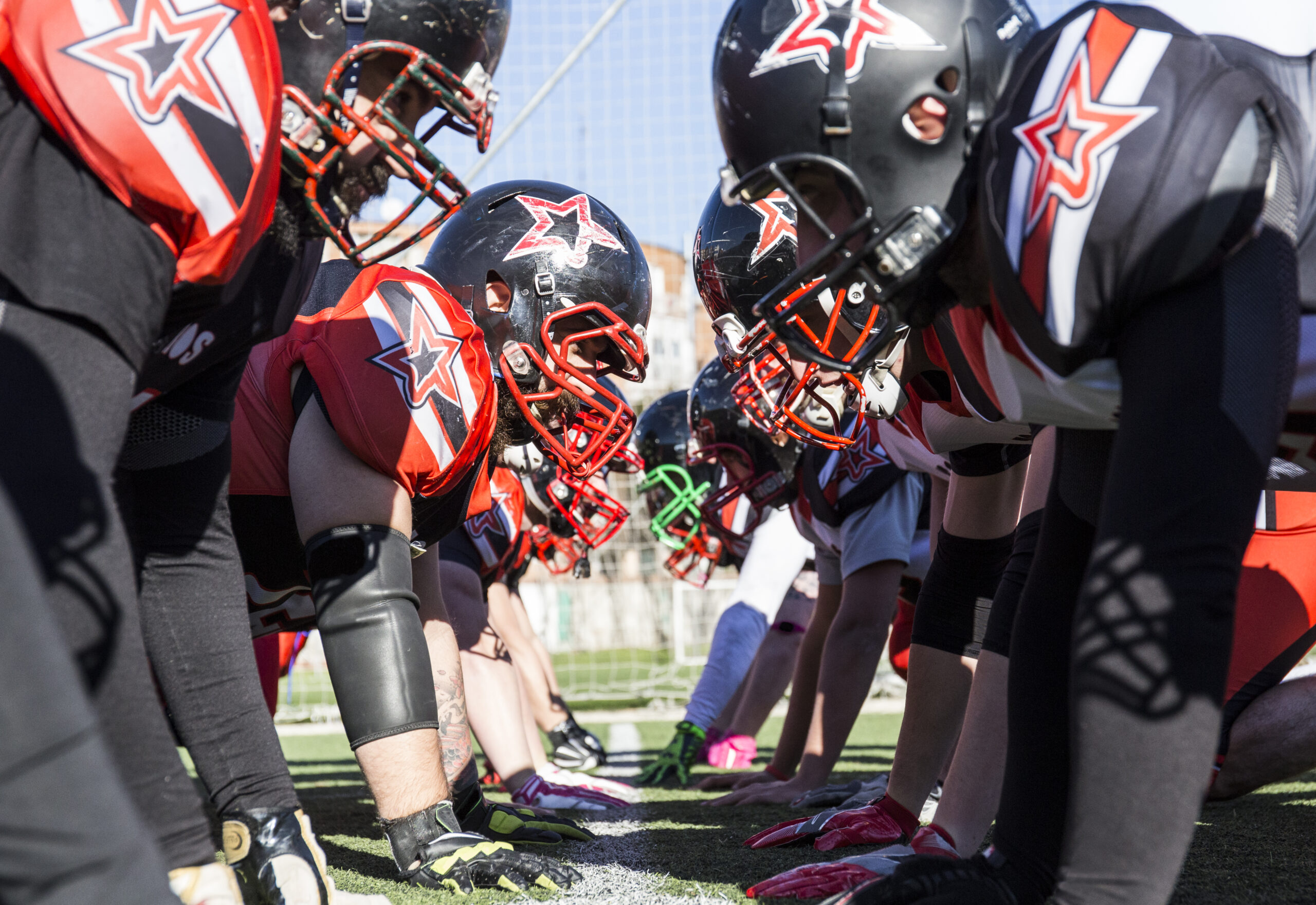 High school football players on the line of scrimmage, demonstrating teamwork and discipline.