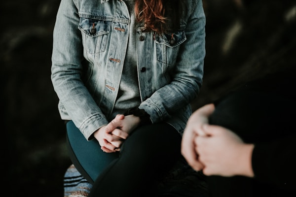 Person with clasped hands, suggesting emotional recovery after a car accident and potential PTSD.