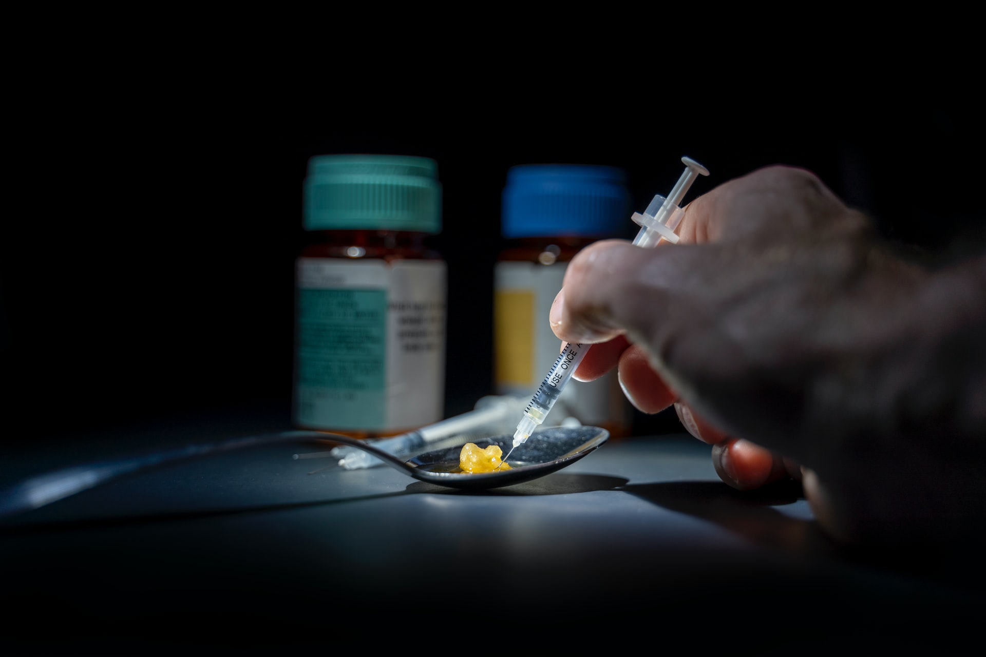 Drug injection and pills illustrating adolescent drug abuse risks and parental guidance.