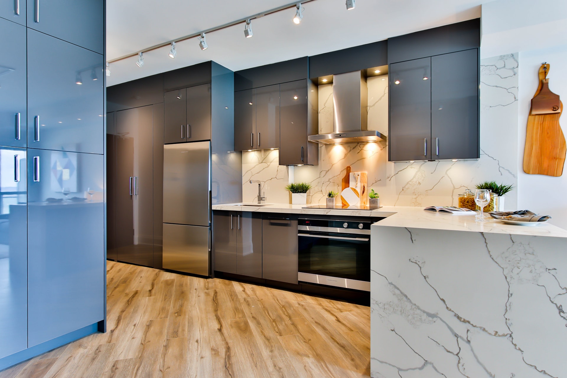 Modern kitchen with stainless steel appliances and marble countertops, representing home protection and maintenance.