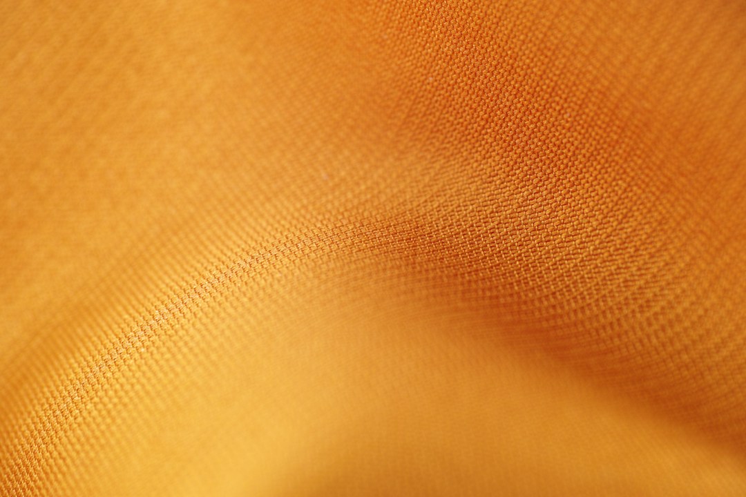 Close-up of textured orange fabric illustrating high-quality materials and chic style