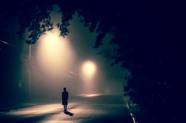 Man silhouetted in darkness, reflecting alcohol abuse and its consequences.